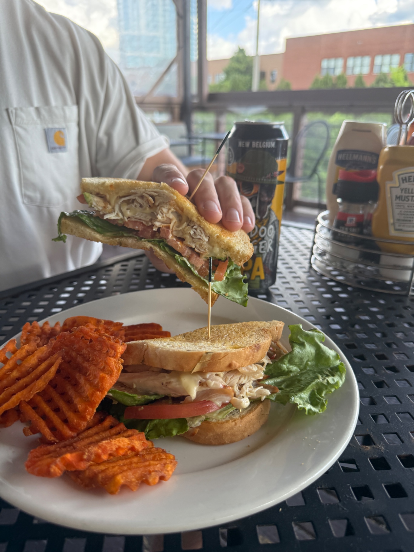 Turkey club sandwich with sweet potato waffle fries on the patio